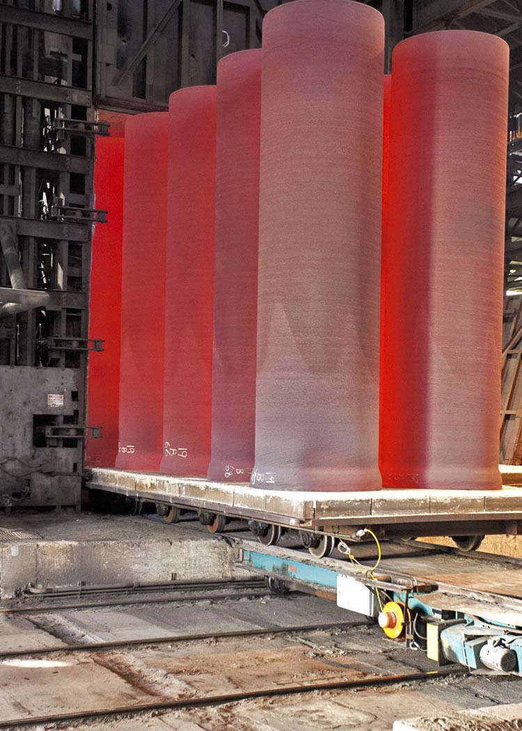 Ductile Iron Pipe being produced at a steel foundry. They are red hot due to their extreme temperature.